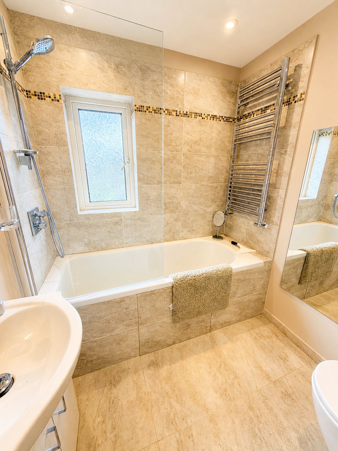 First-floor bathroom with bath, shower screen, basin and toilet