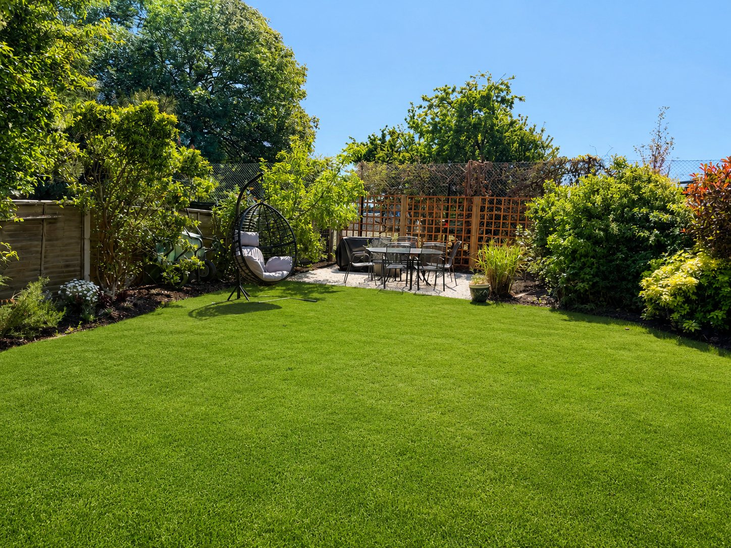 Wide lawn leading to the outdoor dining area at the end of the garden