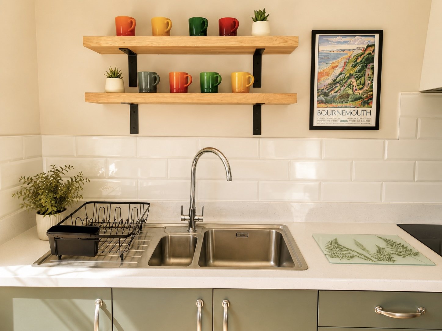 Kitchen sink area with colourful mugs and Bournemouth print